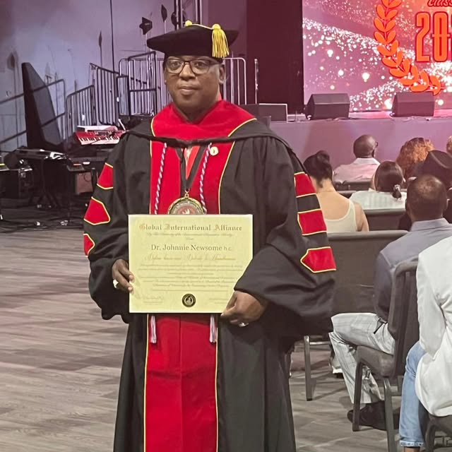 Johnnie holding his doctoral certificate